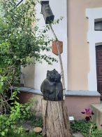 Деревянная скульптура кота возле башни